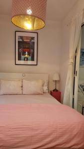 um quarto com uma cama rosa e um lustre em Mini Cooper Kajzerica em Zagreb