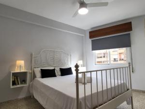 a white bedroom with a bed and a window at Motril centro. in Motril