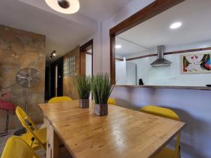 uma sala de jantar com uma mesa de madeira e cadeiras amarelas em Motril centro. em Motril