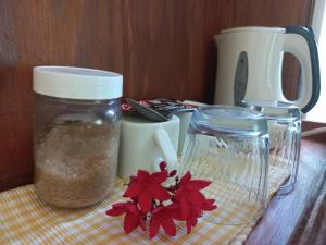 a table with a jar of seasoning and a red flower at Serenity Lodges Dominica in Marigot