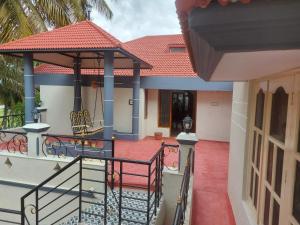 een huis met een balkon en een tuinhuisje bij N A S HOMESTAY in Mysore