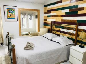 um quarto com uma cama com uma parede em madeira em Pé do Castelo Casinha em Tomar