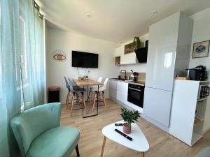 a kitchen and living room with a table and a chair at -Ty Cosy- T2 Wifi Netflix Parking Lave Linge in Ergué-Gabéric