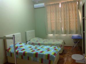 a small bedroom with two beds and a window at Pan Homestay in Kuantan