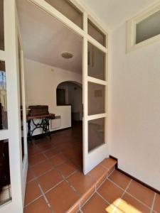 corridoio con camera con tavolo e piano di Casa Alta a Lugano