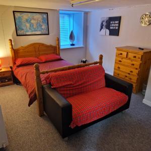 a bedroom with a bed and a chair at Hide away (Central Inverurie) in Inverurie