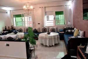 Appartement traditionnel marocain & spacieux في فاس: غرفة معيشة مع طاولة وأريكة