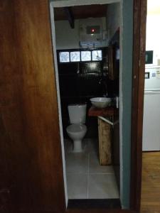 a small bathroom with a toilet and a sink at Cabañas 5 Brujas in Punta Del Diablo