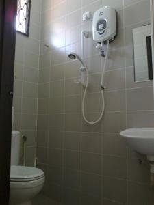a shower in a bathroom with a toilet and sink at Pan Homestay in Kuantan
