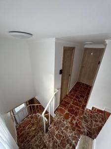Habitación con escalera, suelo de piedra y puerta. en A Casa de Santos en Combarro