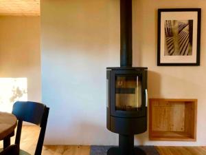 a stove in a living room with a table at LA CÀ NOVA. South Switzerland cozy gate away. in Osco
