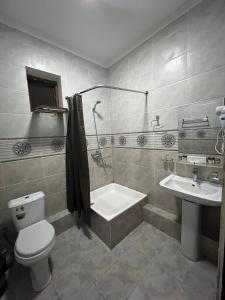 a bathroom with a tub and a toilet and a sink at Al Arda Avenue in Tashkent