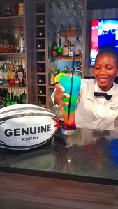 a man standing behind a bar holding a drink at Sasavona Boutique Hotel in Polokwane