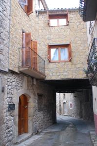 um beco com um edifício com janelas e uma varanda em Cal Balico Fatarella em Fatarella