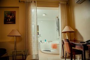 a bathroom with a tub and a sink in a room at Shangri-la Hotel Muyenga in Bugolobi