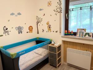 ein Kinderzimmer mit einem blauen Bett und Wandstickern in der Unterkunft An Wanderwegen gelegen mit Terrasse und Boxspringbett in Sasbachwalden