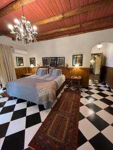 um quarto com uma cama e um piso em xadrez em Hotel Vendimia Parador em Santa Cruz