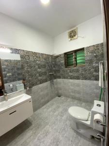 a bathroom with a toilet and a sink at Alpha Guest House in Rawalpindi