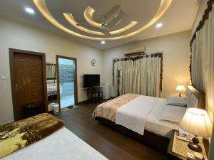 Habitación de hotel con cama grande y techo circular. en Alpha Guest House, en Rawalpindi