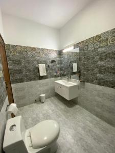 y baño con aseo y lavamanos. en Alpha Guest House, en Rawalpindi