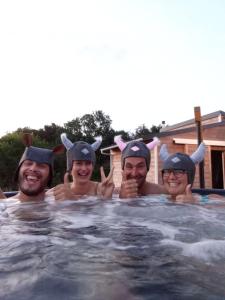 eine Gruppe von drei Männern in Kostümen in einem Schwimmbad in der Unterkunft Spa & Bain Nordique - Tiny house à la campagne in La Boissière