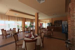 ein Restaurant mit Tischen und Stühlen und eine Bar in der Unterkunft Galeria Holiday Apartments in Obsor