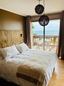 a bedroom with a bed with a view of the ocean at Blumen Hotel in Concón