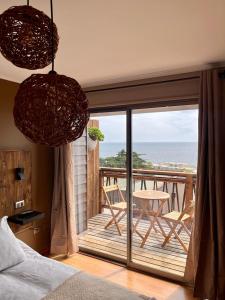a bedroom with a balcony with a view of the ocean at Blumen Hotel in Concón