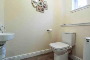 une salle de bain avec des toilettes blanches et un lavabo dans l'établissement Beautiful, cosy home in Connel, 5 mile drive from Oban, à Connel 2 autres photos
