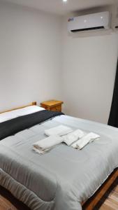 Una cama con dos toallas blancas encima. en El Caldén en Cañuelas