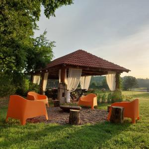 einen Pavillon mit orangefarbenen Stühlen im Gras in der Unterkunft Pensjonat Poranna Rosa in Grabowiec