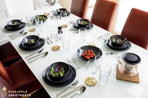 a table with black plates and bowls of food on it at Pineapple Apartments Dresden Mitte - free parking in Dresden