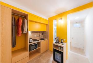 a small kitchen with yellow walls and a stove at La Casa del Sarto Amalfi in Amalfi