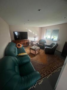 a living room with a green couch and a table at Puppenhaus 