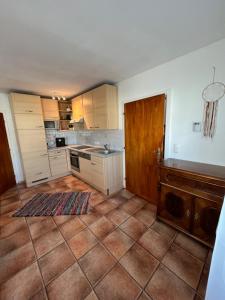 una cucina con armadietti bianchi e pavimento piastrellato di Boho Home am Bach ad Altmünster Altre 13 foto