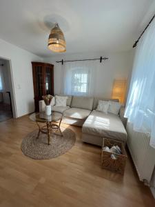 een woonkamer met een witte bank en een tafel bij Boho Home am Bach in Altmünster