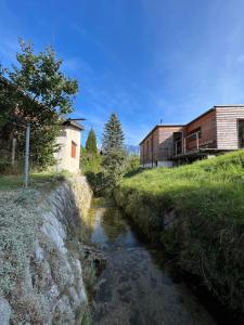 un ruscello accanto a un edificio e a una casa di Boho Home am Bach ad Altmünster
