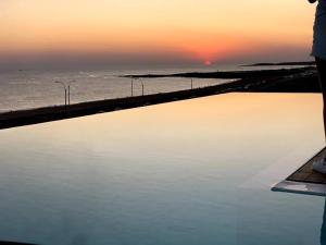 een zwembad met een zonsondergang op de achtergrond bij Maravilloso Departamento al Mar in Punta del Este