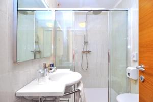 a white bathroom with a sink and a shower at Eco Hotel Cleofe in Caorle