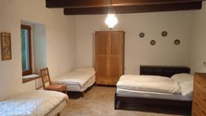 1 dormitorio con 2 camas, armario y silla en Vidiecky domček na samote, 
