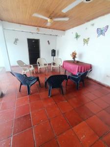 Habitación con mesa, sillas y mariposas en la pared. en Hospedaje Doña Victoria, en Santa Marta