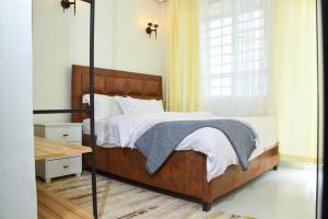 Executive Two & Three Bedroom Suites في ناكورو: غرفة نوم بسرير ونافذة ذات ستائر صفراء