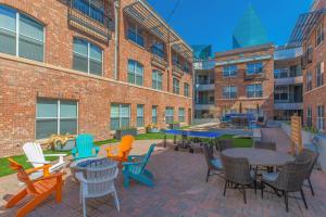 a patio with colorful chairs and tables in front of a building at Modern 1BR Apt I Dallas City Center I Pool I Gym I Workspace I Pets in Dallas