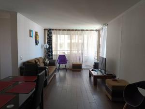 sala de estar con sofá y mesa en Luminoso depto 3 dormitorios 2 baños frente al mar en Iquique