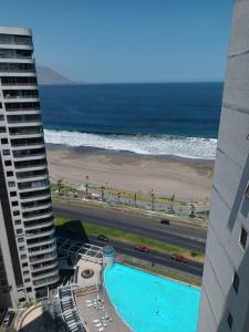 a view of the beach from a building with a swimming pool at Luminoso depto 3 dormitorios 2 baños frente al mar in Iquique