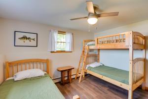 a bedroom with two bunk beds and a ceiling fan at Waterfront Sidney Getaway with Private Dock! in Belgrade