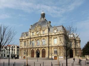 un gran edificio con un reloj encima en Appt cosy en cœur de ville proche Lille - 15 min en Tourcoing