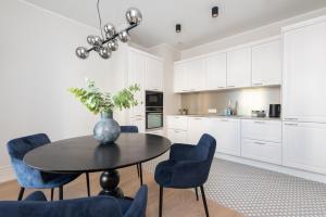 a kitchen with a table and some blue chairs at Hilltop Apartments - City Centre in Tallinn