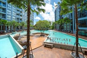 ein großer Pool mit Palmen und Gebäuden in der Unterkunft 5 Stars Facilities Condo Kamala Beach in Kamala Beach