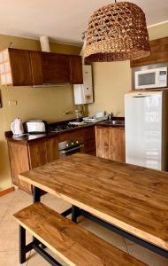 cocina con mesa de madera y nevera en Blumen Hotel en Concón